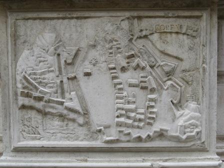 A relief carving of the town and Old Fortress (at the time, the Only Fortress) of Corfu, affixed to the facade of the church of Santa Maria del Giglio in Venice.  It is one of six depictions of places at which Adm. Antonio Barbaro served the Republic.  If you look at the lower left corner, you see the faint outline of a small harbor containing a large galley.  This is where we kept the gondolone at night; no galleys, but many smallish sailboats.   