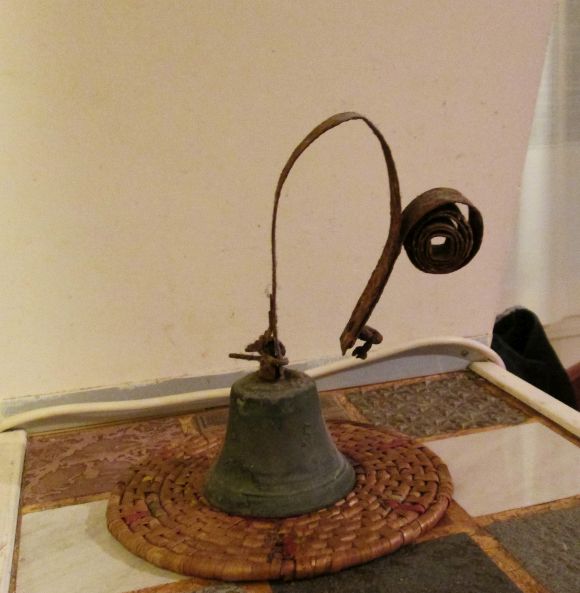 This is the bell that rang in Lino's childhood home, salvaged from an extremely damp (as you see) storage area more or less at canal level.  An object something like a nail (he doen't remember exactly) was passed through the tightly-wound roll of metal on the right, which held the bell upright against the wall.  The wire to be pulled from below was attached just above the bell.  Maybe all that's obvious, but I just thought I'd make sure... 