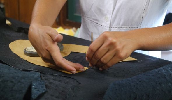 Tracing the shoe's pattern onto a sheet of ostrich-skin is careful work, what with the bumps and all.