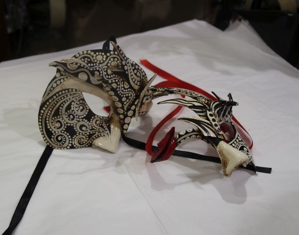 The mask on the right is adorned with a pair or red lips sliced from a plain white mask. 